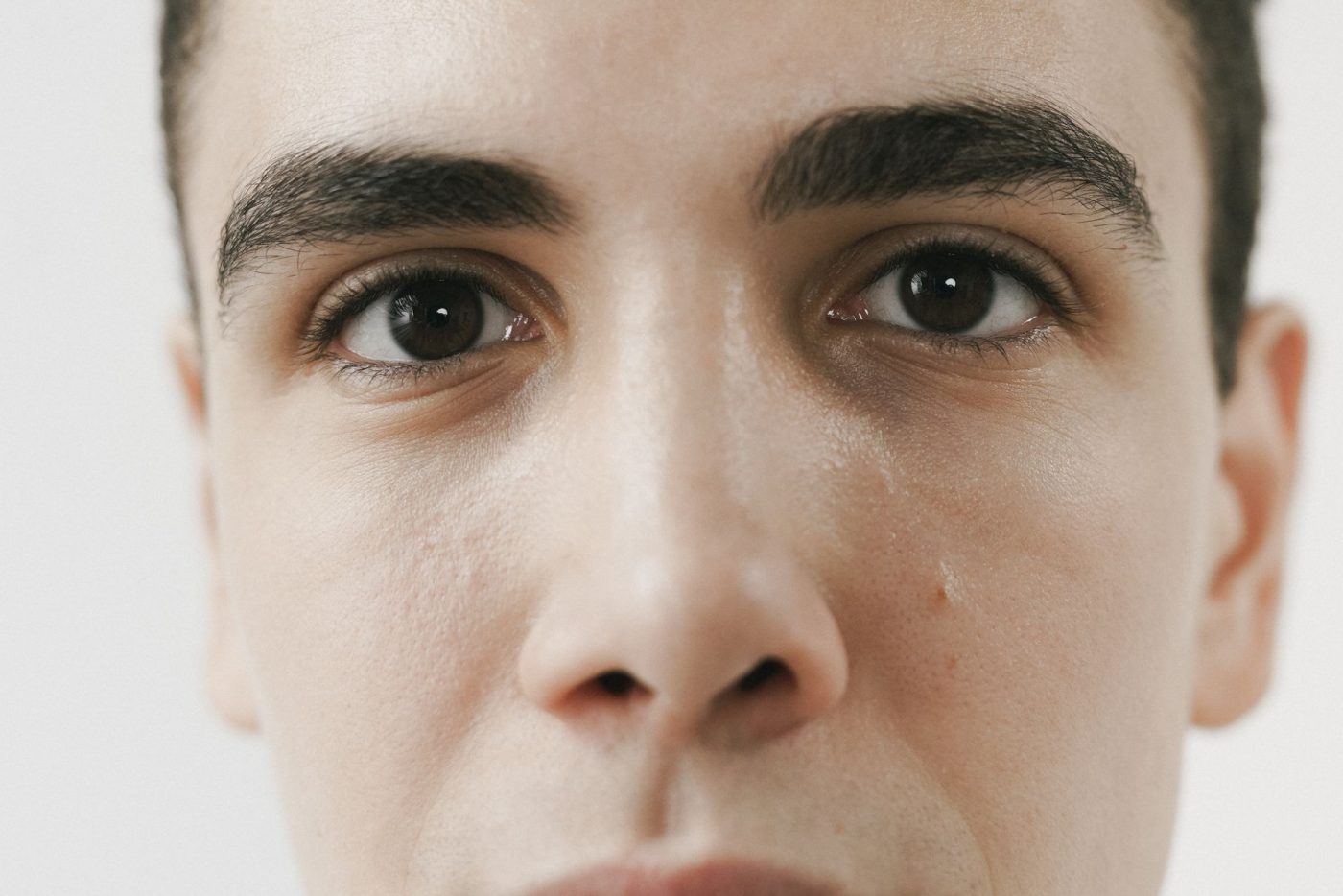 Gros plan sur le visage d'un homme aux sourcils bruns et fournis