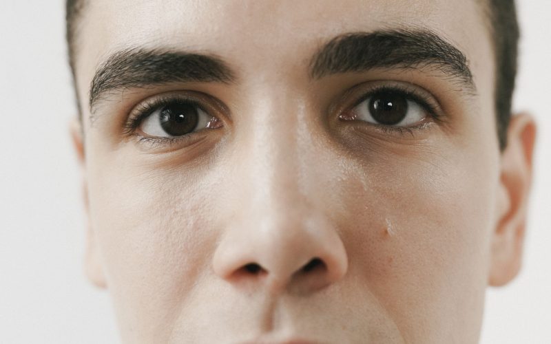 Gros plan sur le visage d'un homme aux sourcils bruns et fournis