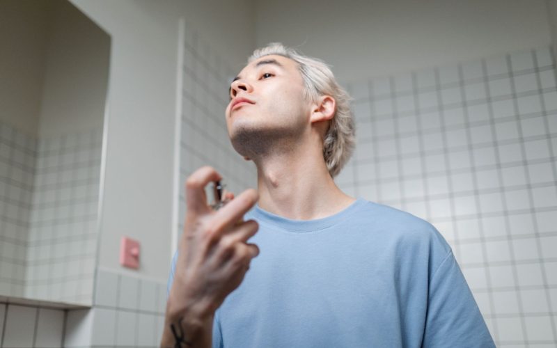 Homme qui vaporise du parfum dans son cou