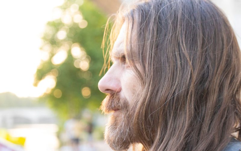 Homme aux cheveux longs et à la barbe, vu de profil au soleil