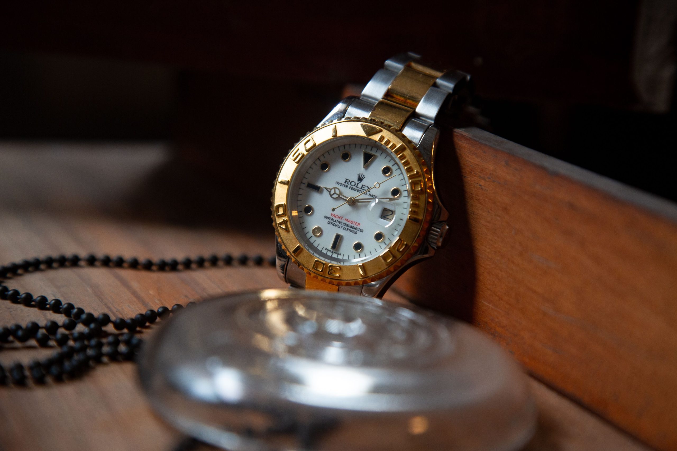 Close-up of a luxury Rolex wristwatch with gold and silver detailing, symbolizing elegance and precision. Gros plan d'une montre-bracelet Rolex de luxe avec des détails en or et en argent, symbolisant l'élégance et la précision.