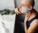 A man applying shaving cream while grooming in a bathroom at home. Un homme appliquant de la crème à raser tout en se toilettant dans une salle de bain à domicile.