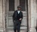 Full body of confident man in stylish formal suit standing with hand in pocket near aged door of building in daylight Homme en costume formel élégant et confiant, debout la main dans la poche près d'une porte ancienne d'un bâtiment en plein jour