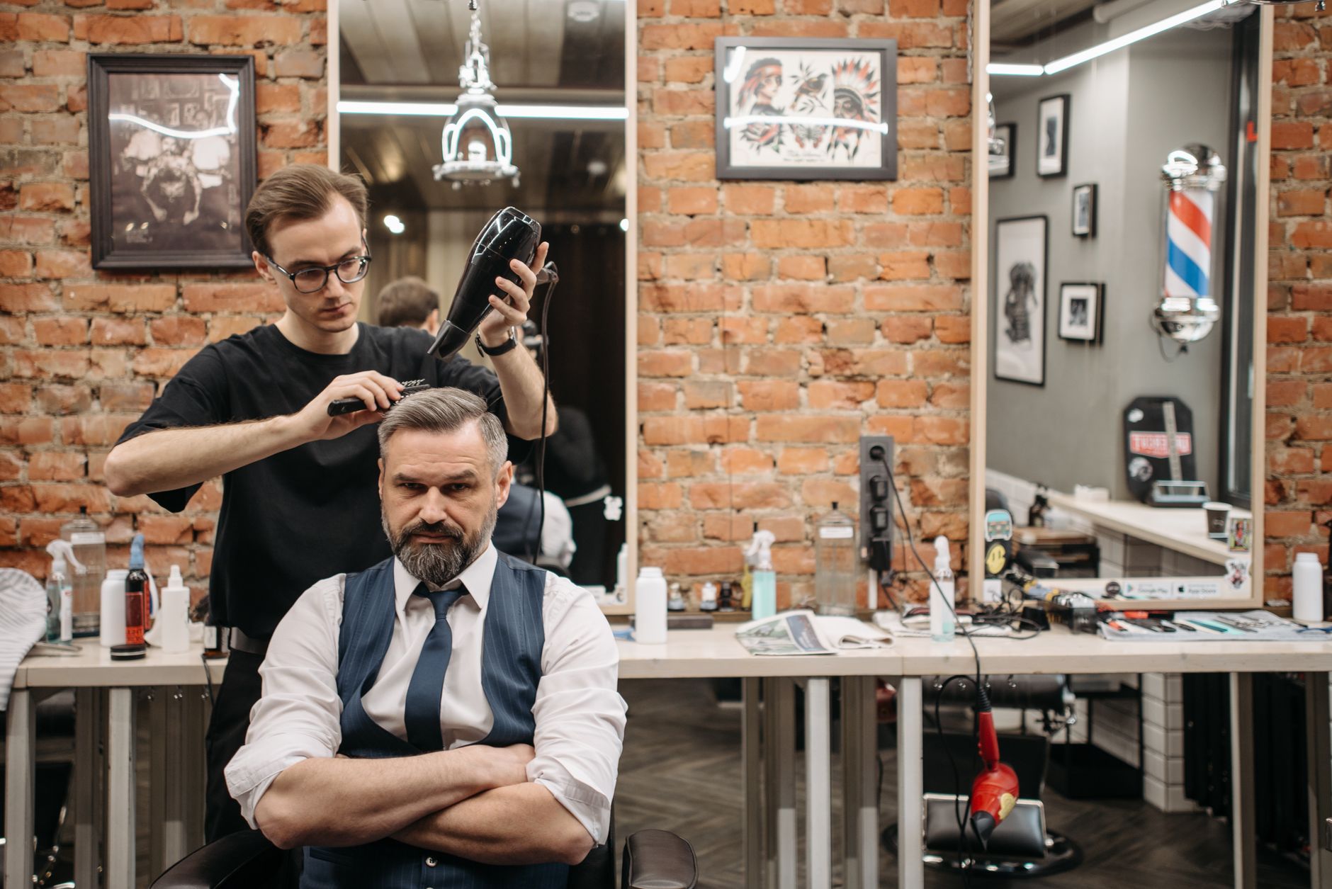 Barbier coiffant un client en salon