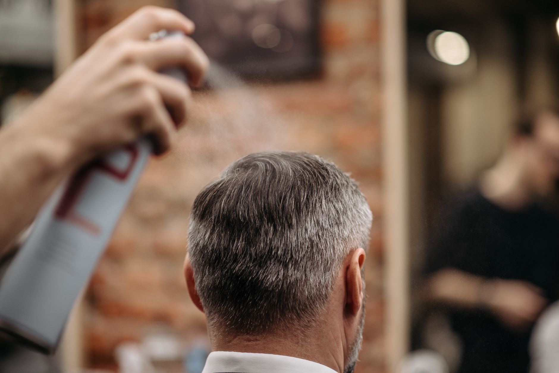 Barbier stylisant les cheveux d'un client en salon