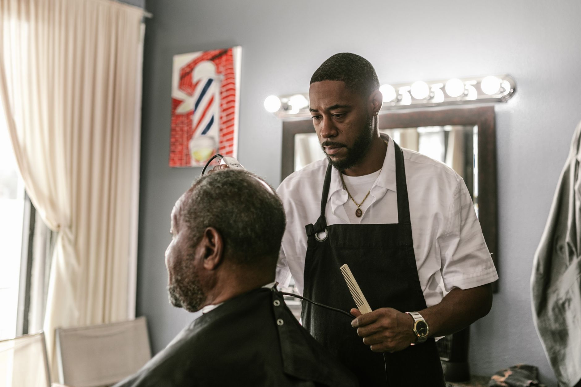 Coiffeur qui coiffe un client en salon