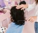 Close-up of a woman receiving hairstyling treatment in a contemporary salon. Gros plan d'une femme recevant un traitement de coiffure dans un salon contemporain.