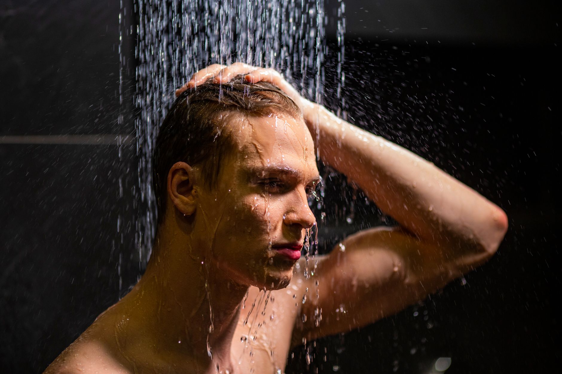 Pourquoi as-tu des pellicules ? Les vraies causes 2 Homme sous la douche qui rince ses cheveux