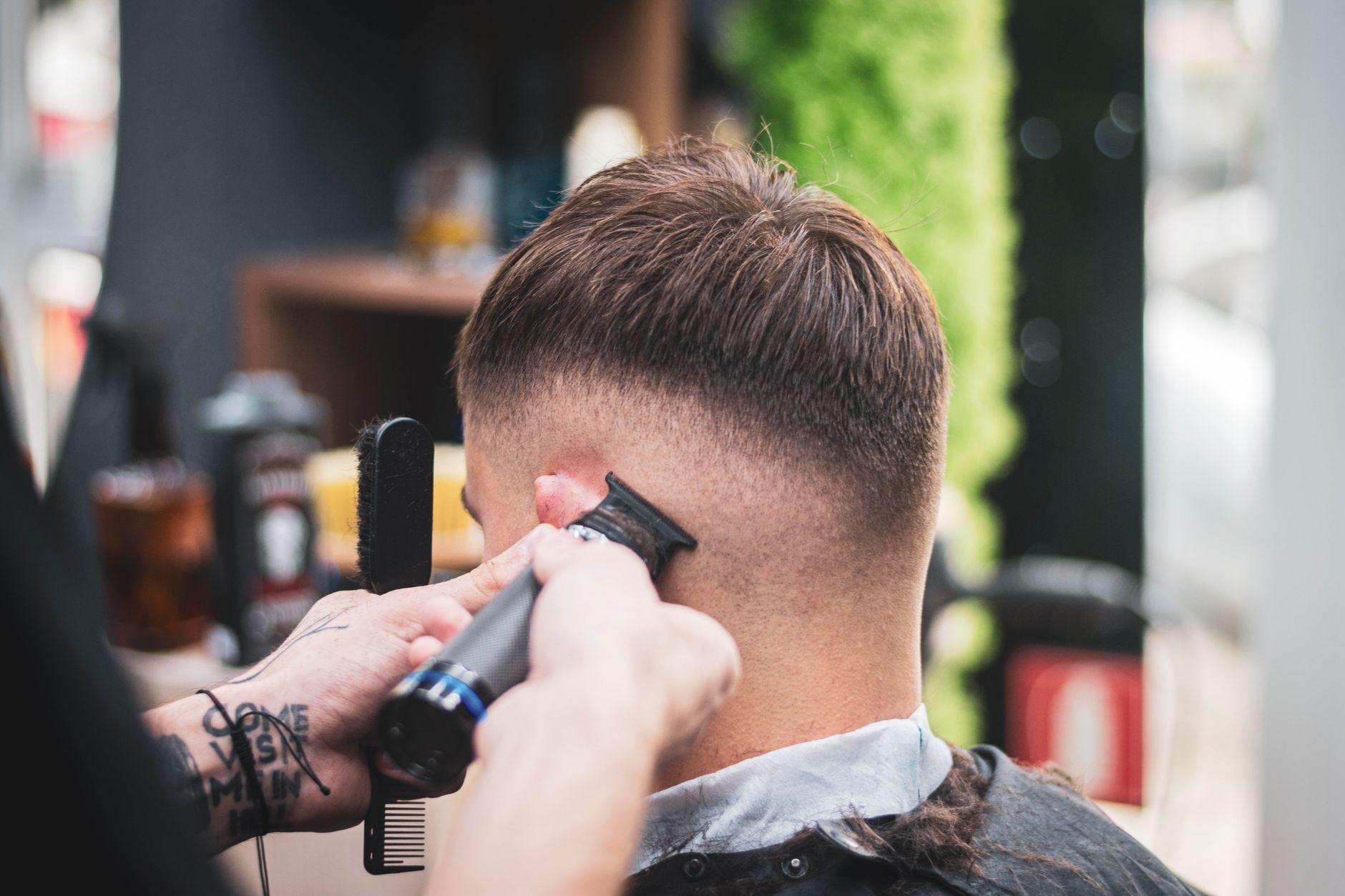 Coiffeur qui dégrade les cheveux courts d'un client à la tondeuse