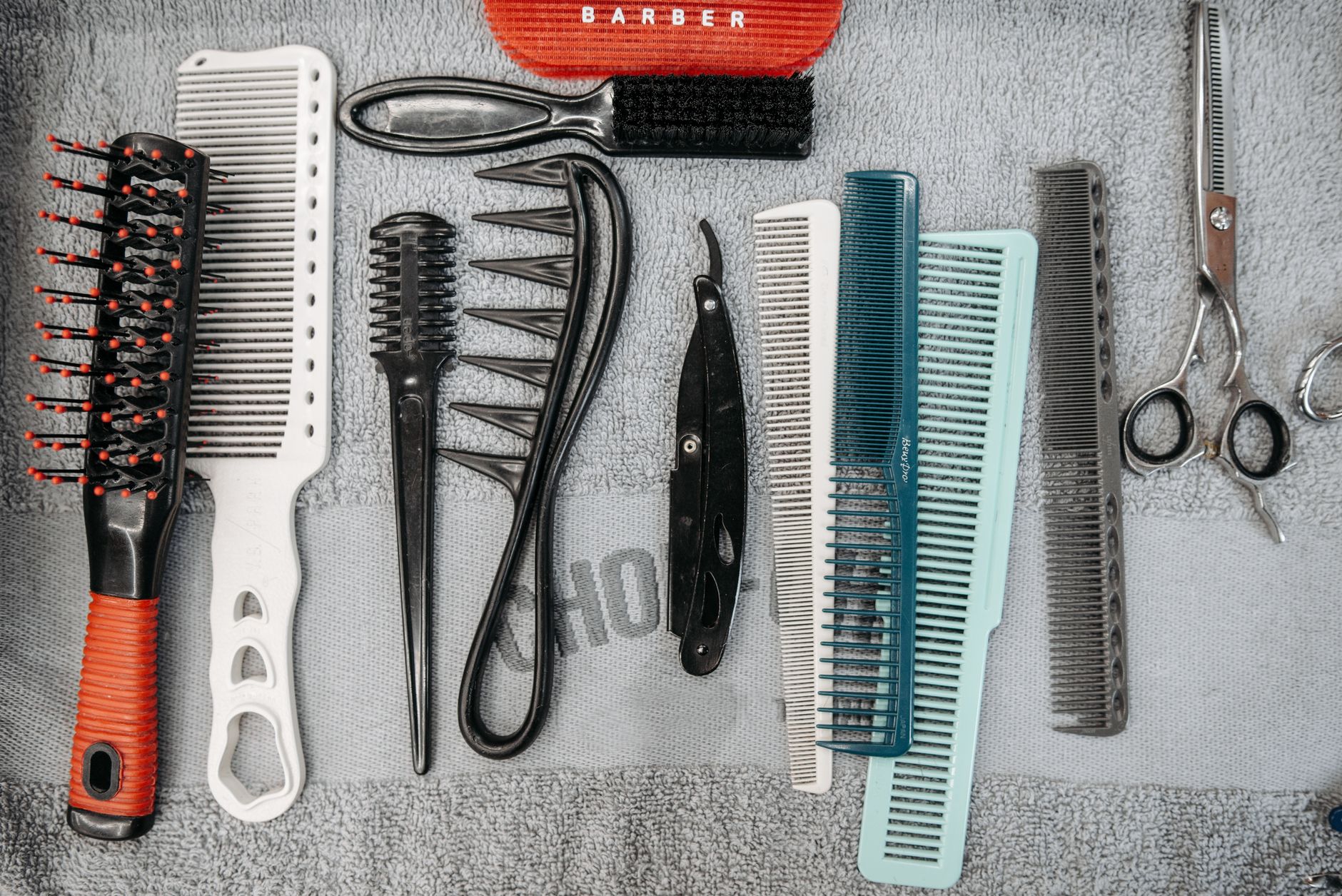 Combien de cheveux perd-on vraiment par jour ? 2 Peignes et ciseaux de coiffure alignés sur une table