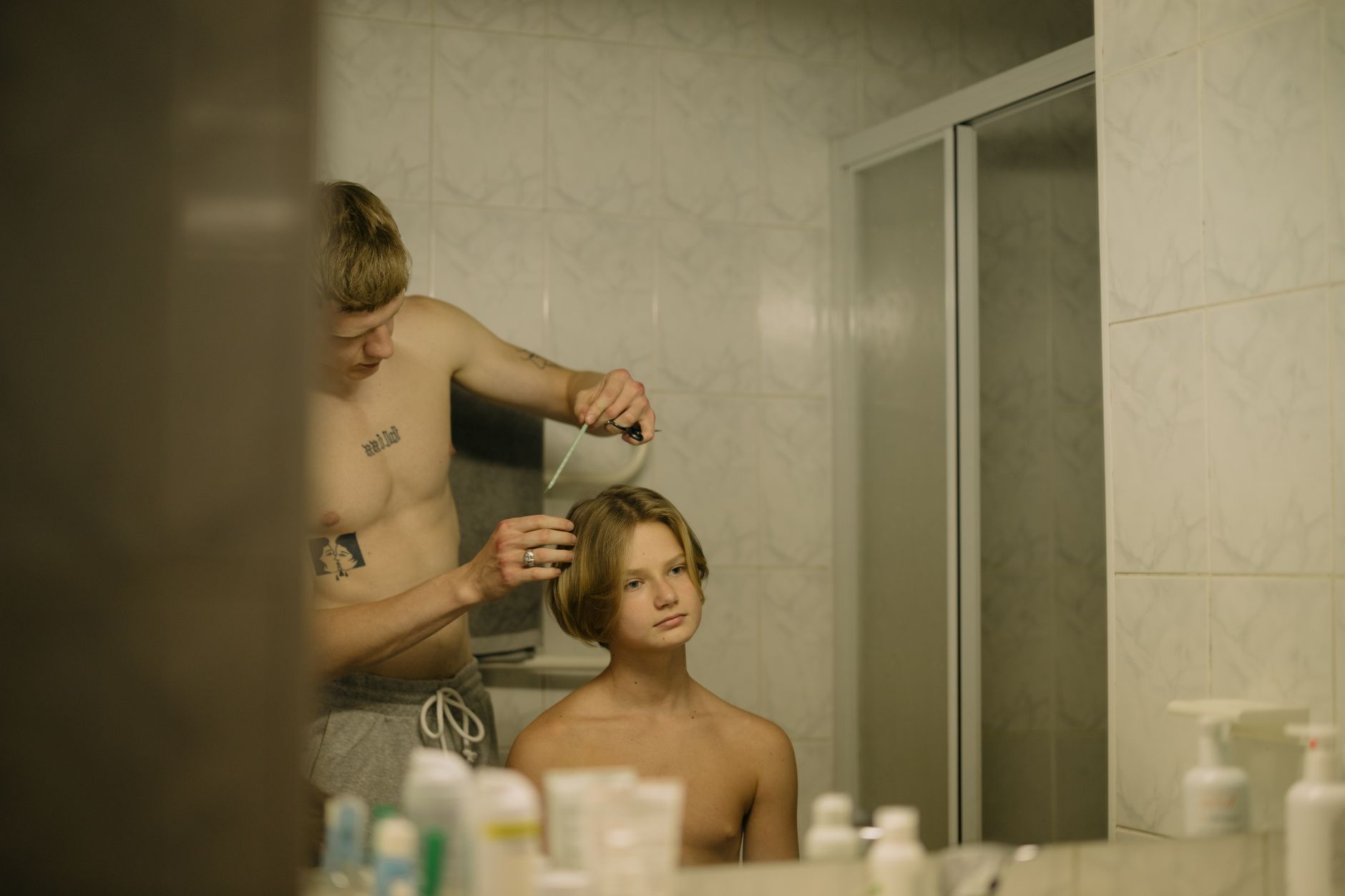 Cheveux gras homme : arrête ces gestes qui aggravent tout 2 Homme tatoué qui se peigne les cheveux