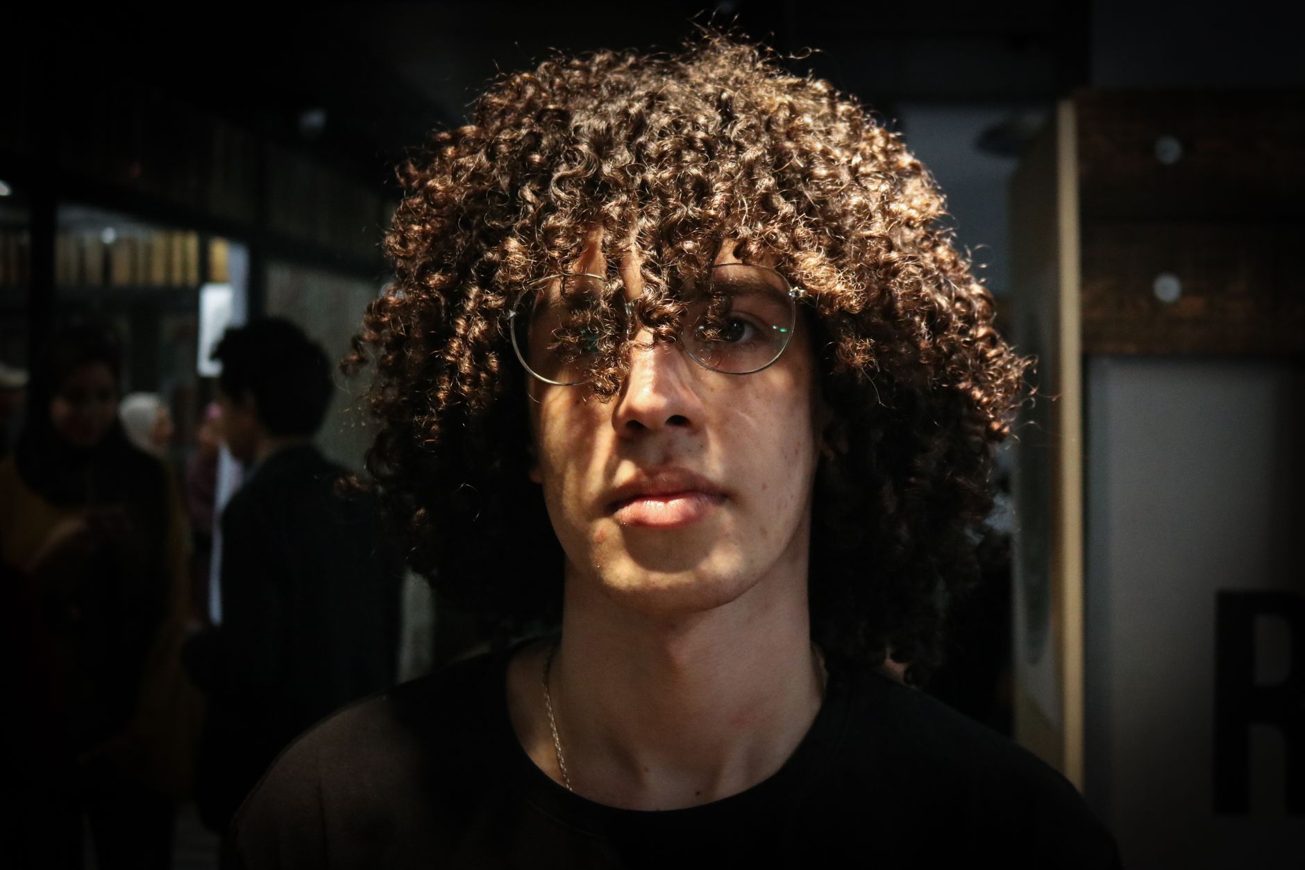 Jeune homme aux cheveux bouclés, portrait exterieur