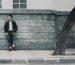 Homme en costume ajuste appuye contre un mur
