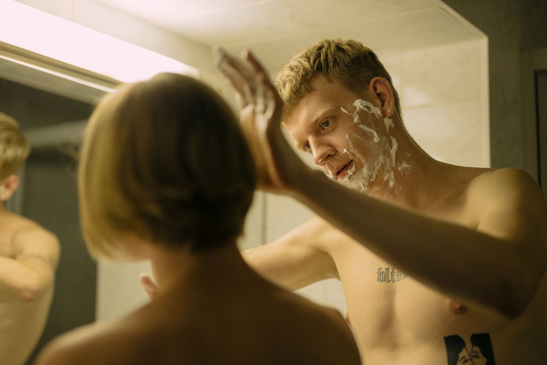 Bien se raser le visage : ma méthode sans irritation 2 Homme applique de la mousse à raser sur la joue