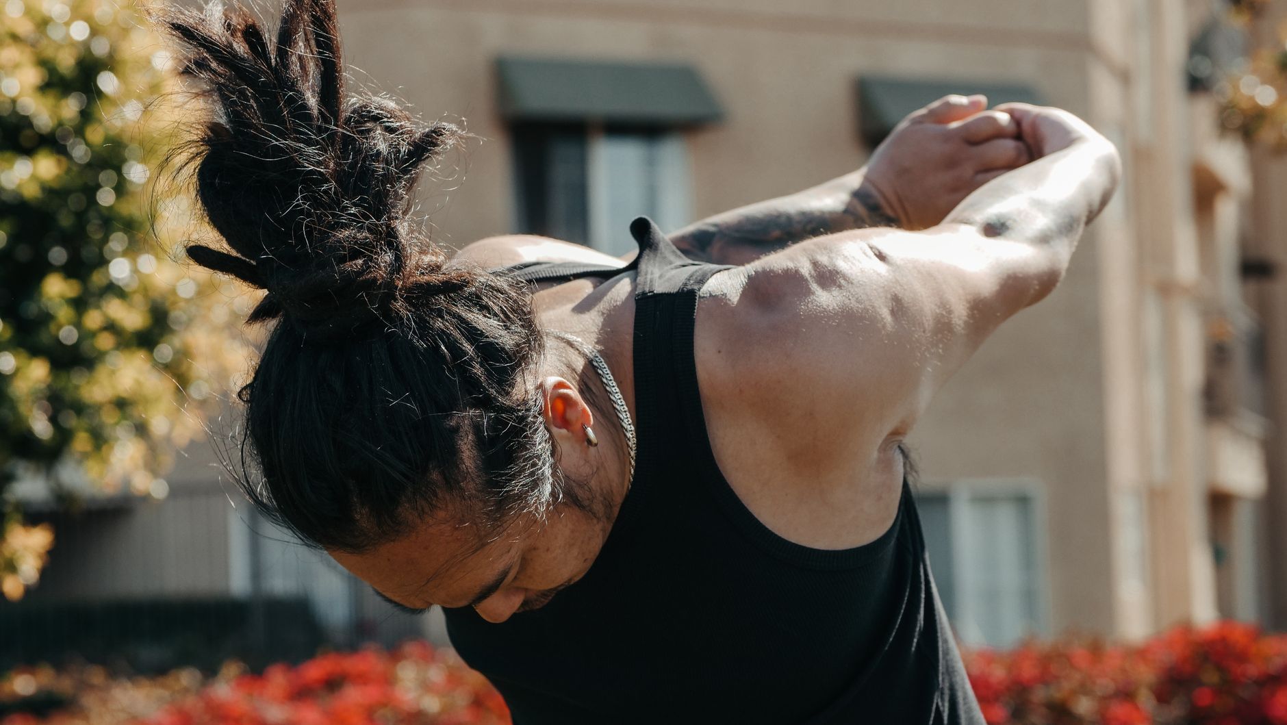 Homme penché qui attache ses dreadlocks en chignon