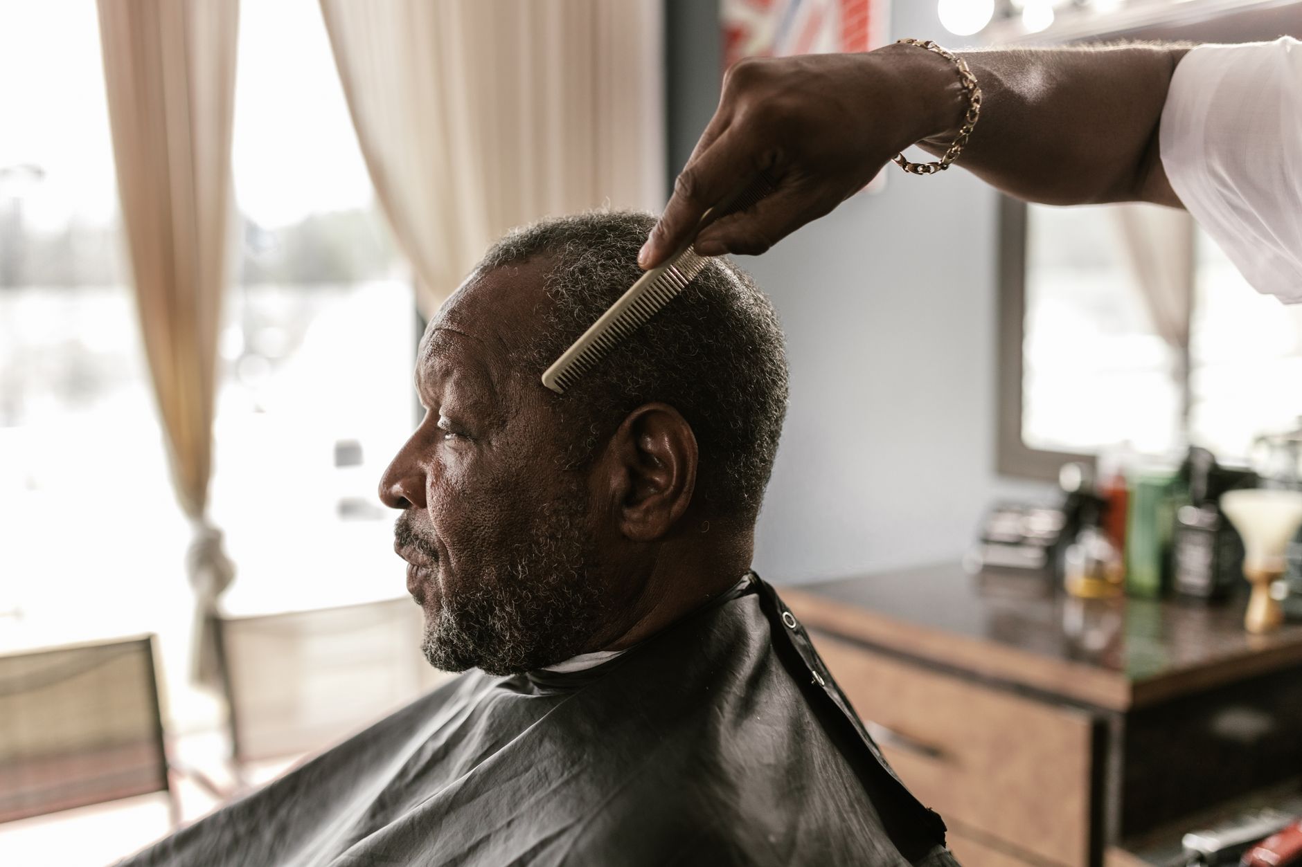 L’huile de ricin fait-elle vraiment pousser tes cheveux ? 1 Homme senior en train de se faire couper les cheveux chez le barbier