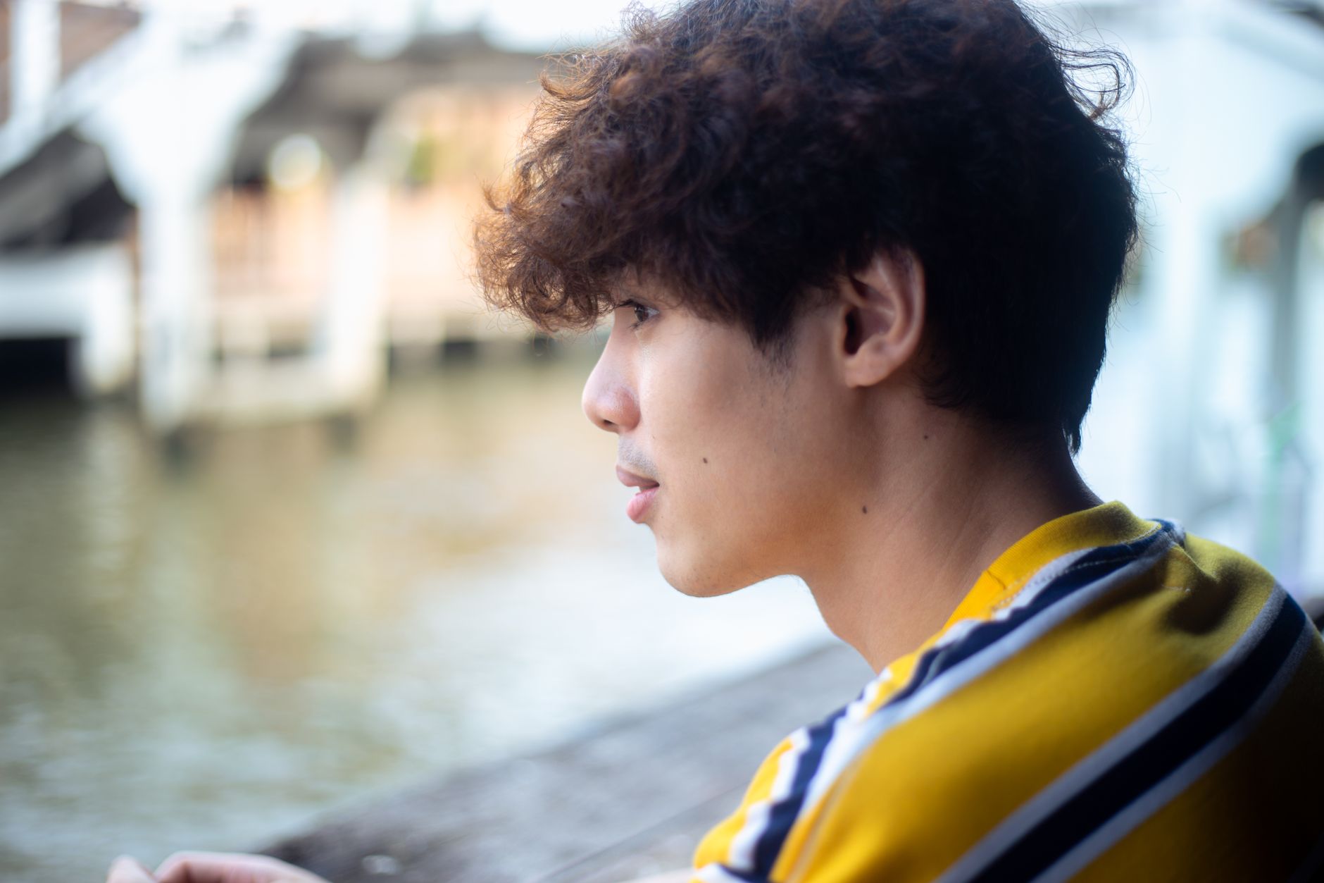 Jeune homme de profil aux boucles souples sur le dessus