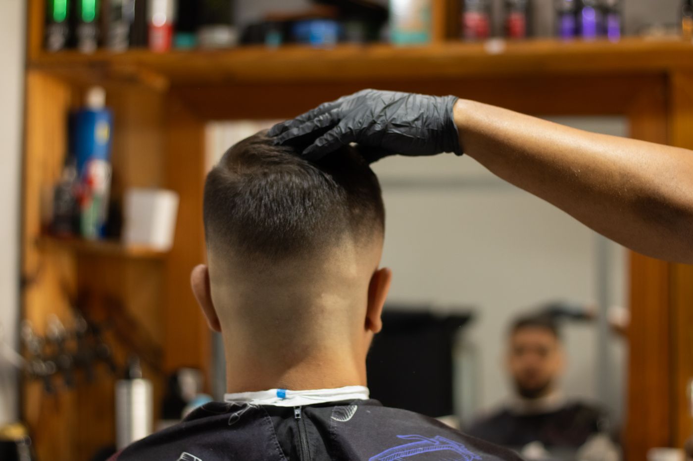 Client vu de dos chez le barbier, fondu progressif de la nuque vers le sommet