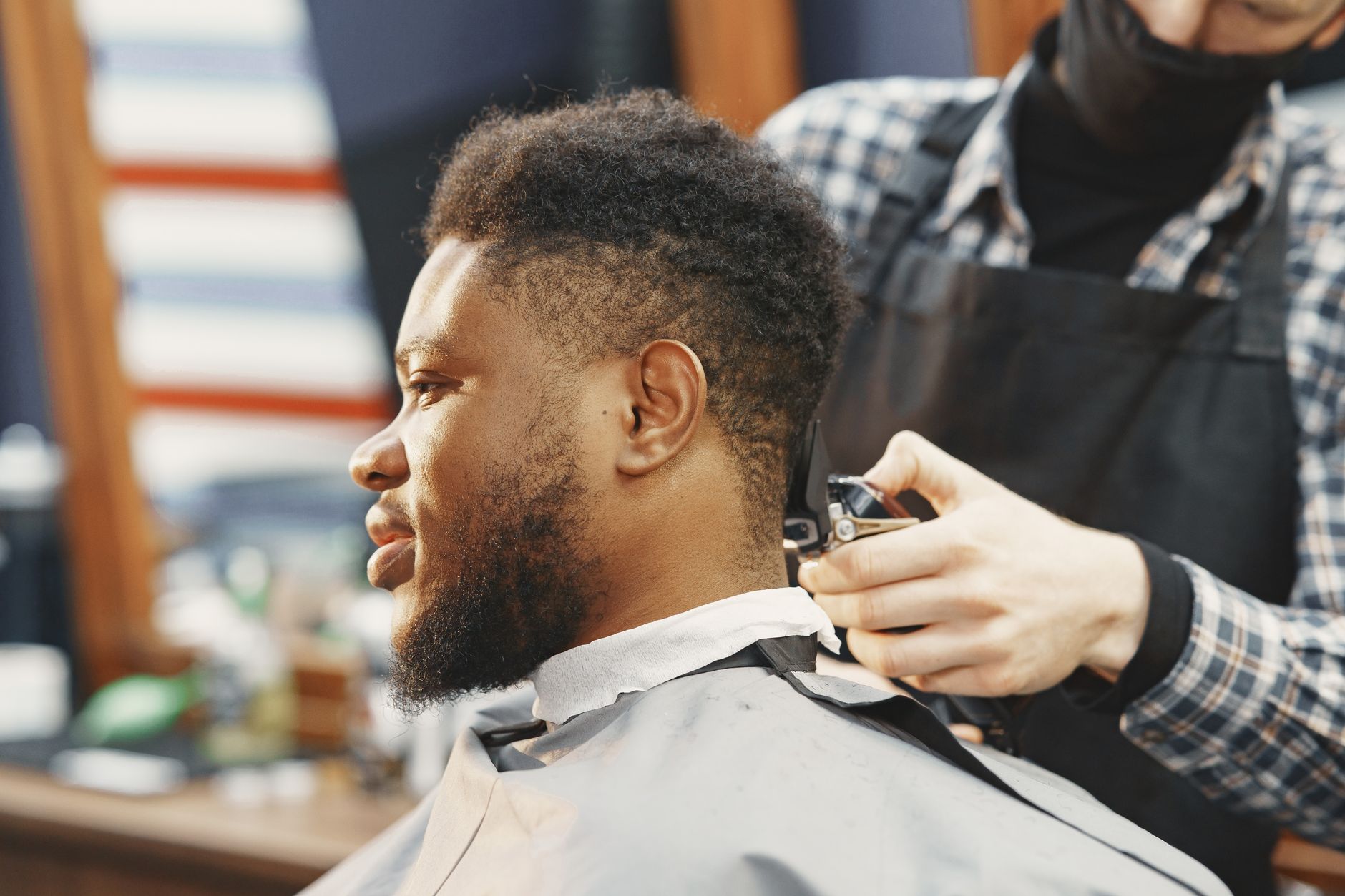 Homme au dessus court et aux côtés dégradés, tondu par un barbier au salon