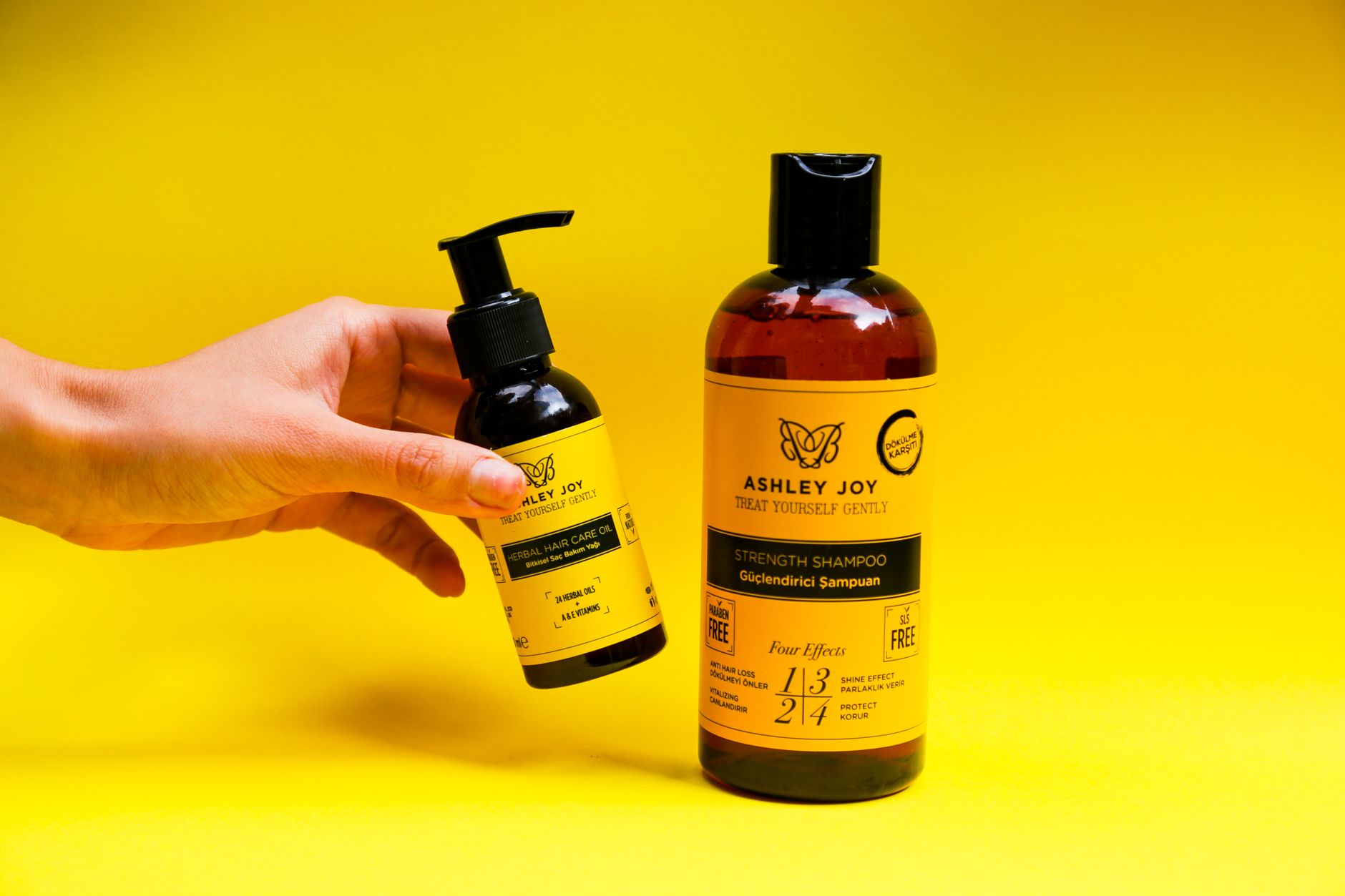 Flacon d’huile capillaire posé à côté d’un shampoing