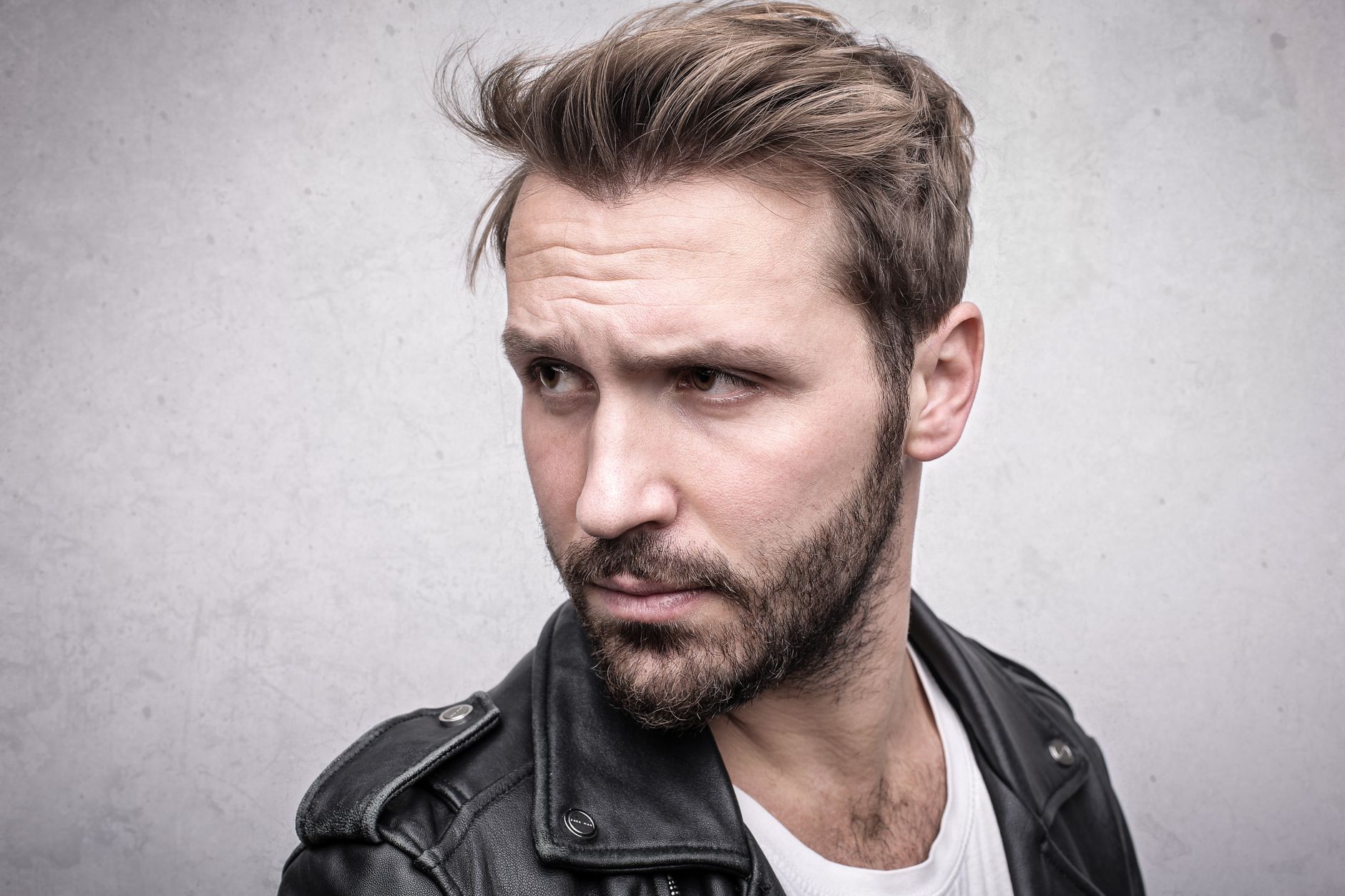 Homme aux cheveux relevés en arrière avec du volume, barbe de quelques jours