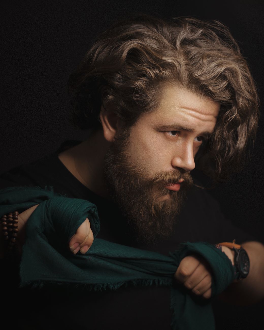 Homme barbu aux cheveux mi-longs ondulés, sur fond sombre