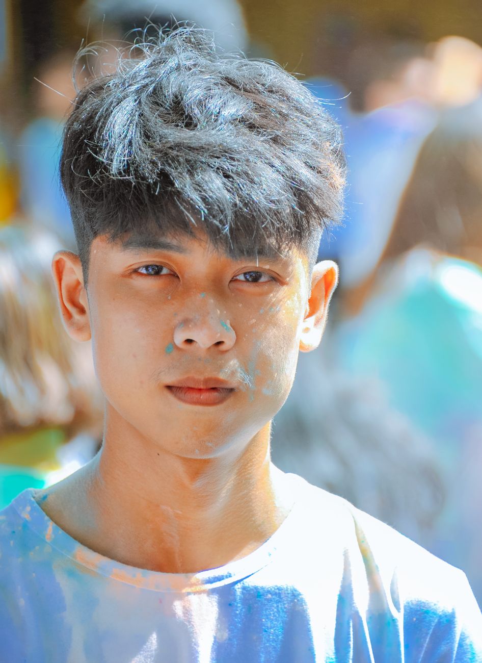 Jeune homme asiatique aux mèches texturées teintées de gris, frange sur les sourcils