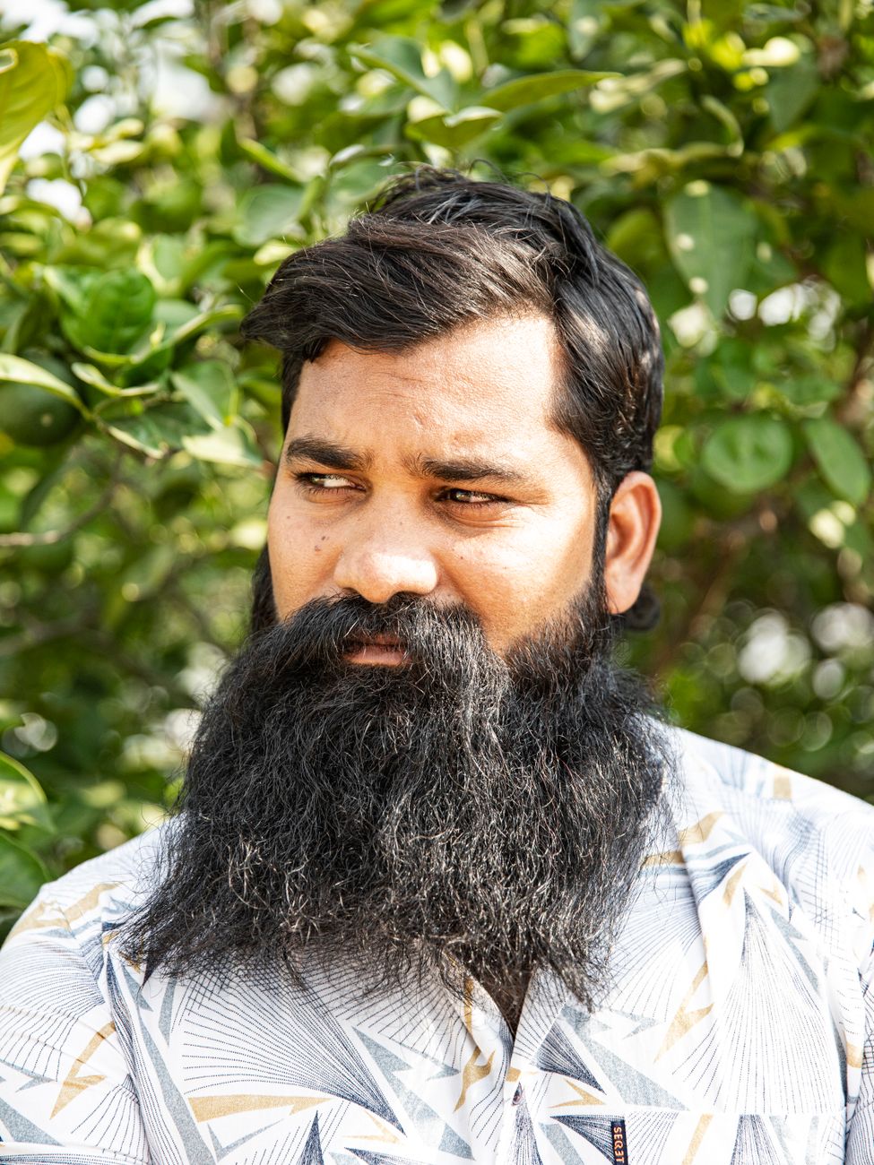 Homme à la barbe noire longue qui s'affine vers le menton
