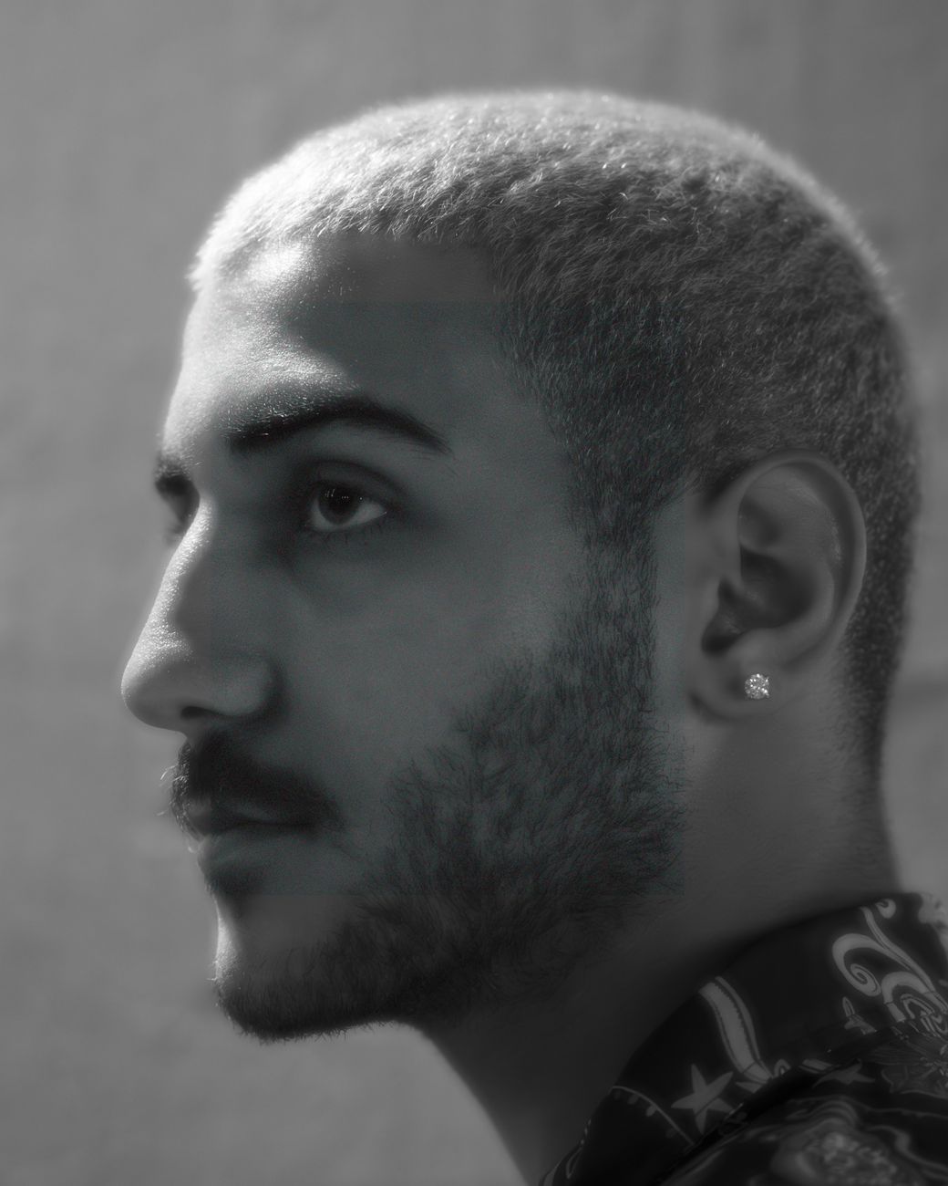 Homme de profil, pattes nettes sous des cheveux courts, en noir et blanc