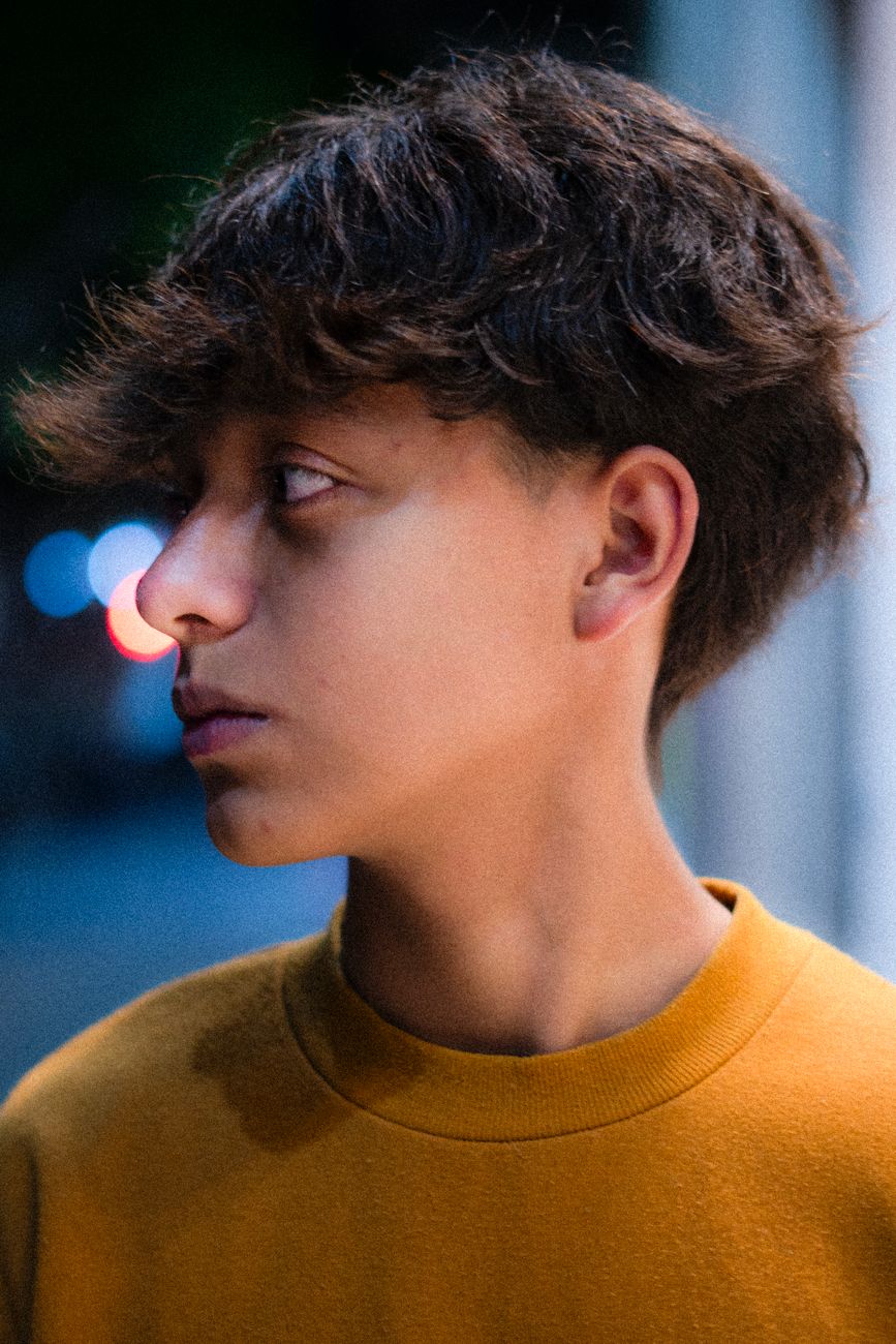 Adolescent de profil au dessus fourni et texturé, pull jaune