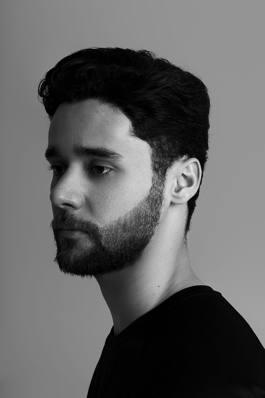 Homme de profil à la barbe courte et à la ligne de cou nette, en noir et blanc