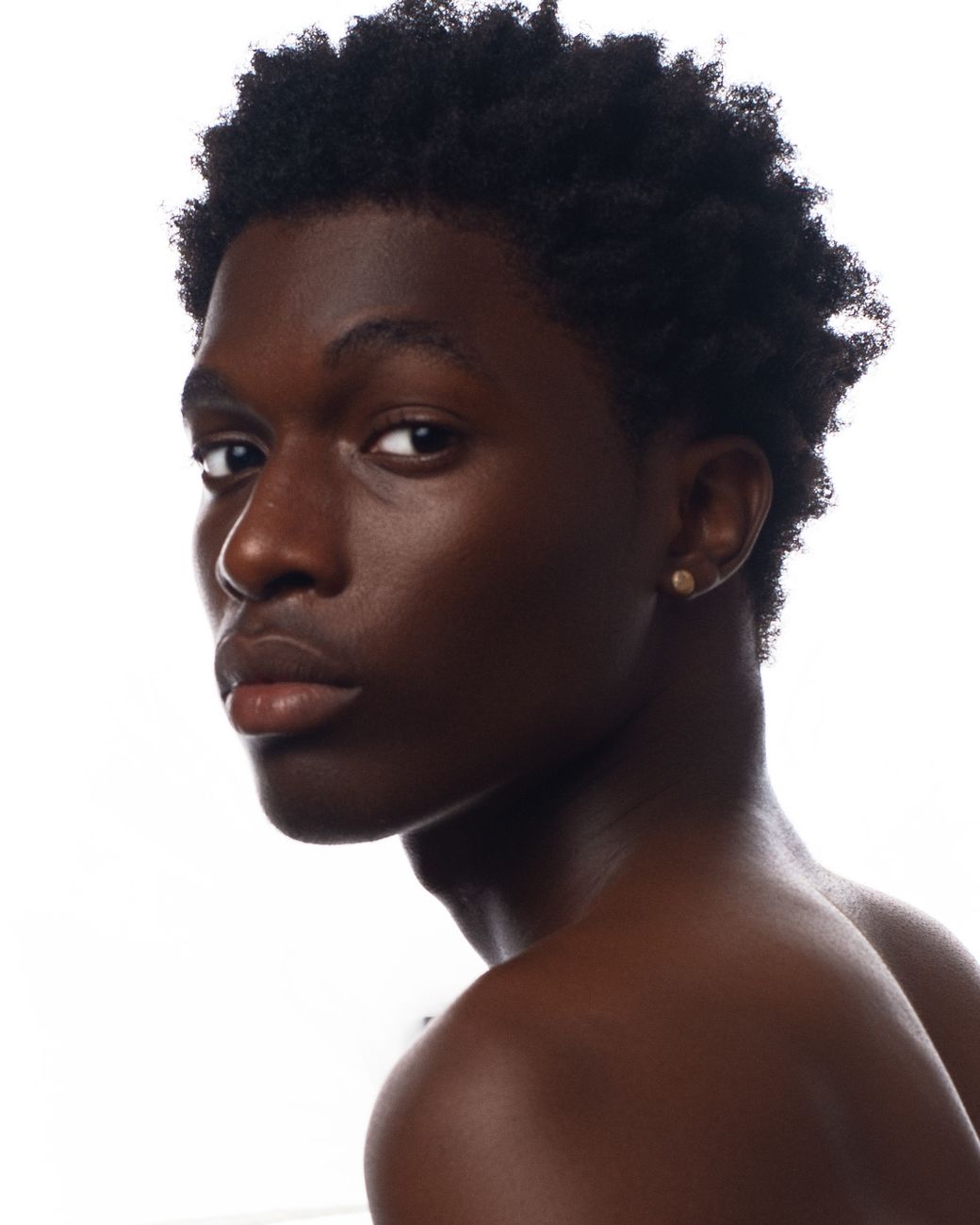 Jeune homme aux cheveux crépus naturels, de trois quarts sur fond blanc