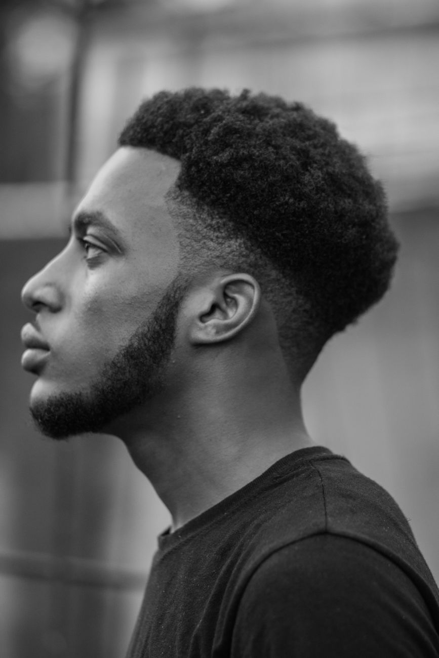 Jeune homme noir de profil, taper net sur la nuque et les tempes, en noir et blanc