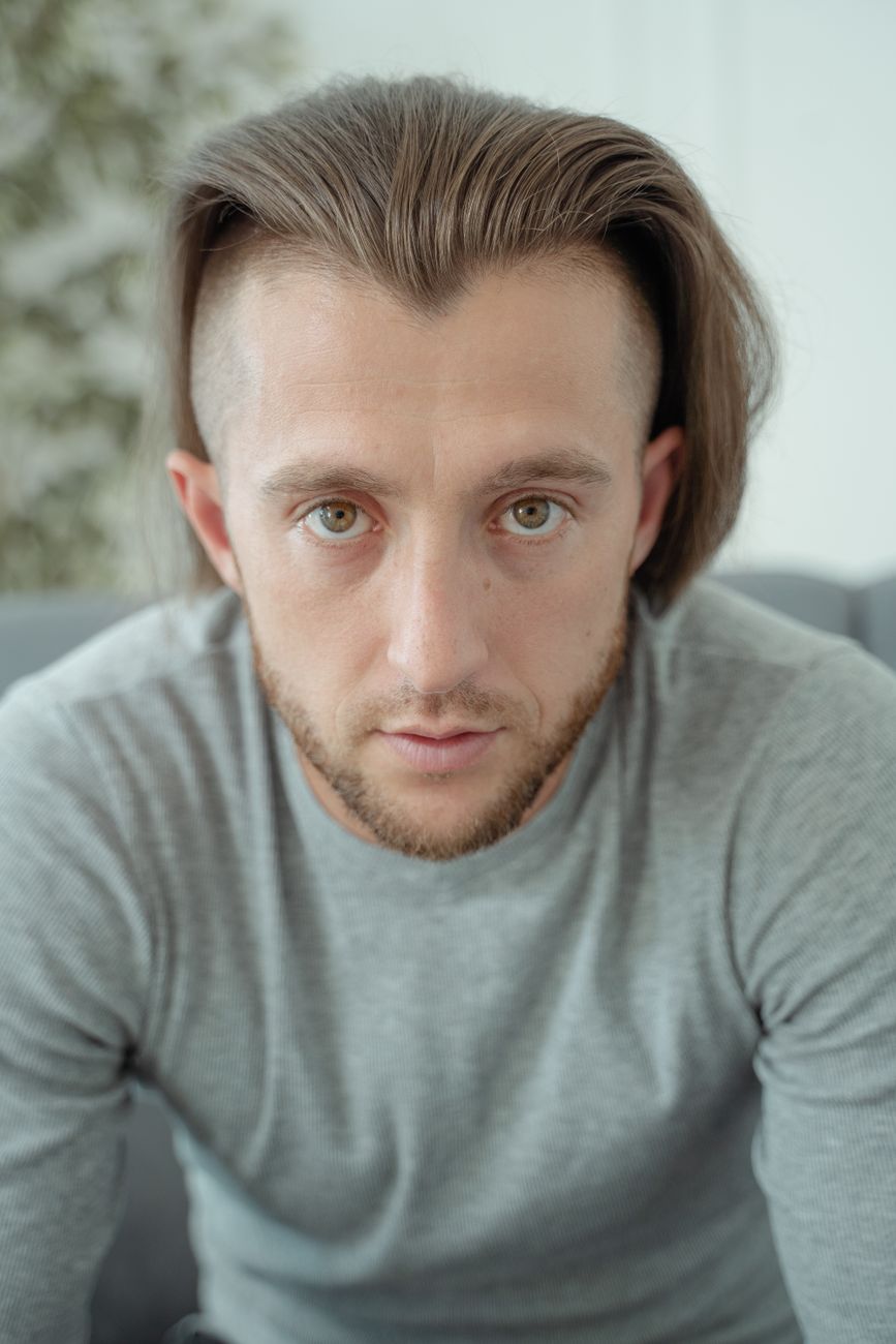 Homme de face, cheveux dégagés du front et barbe courte