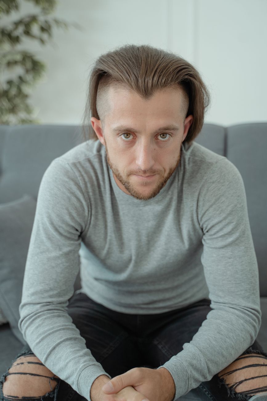 Homme à la raie au milieu, mèches tombant de chaque côté du visage