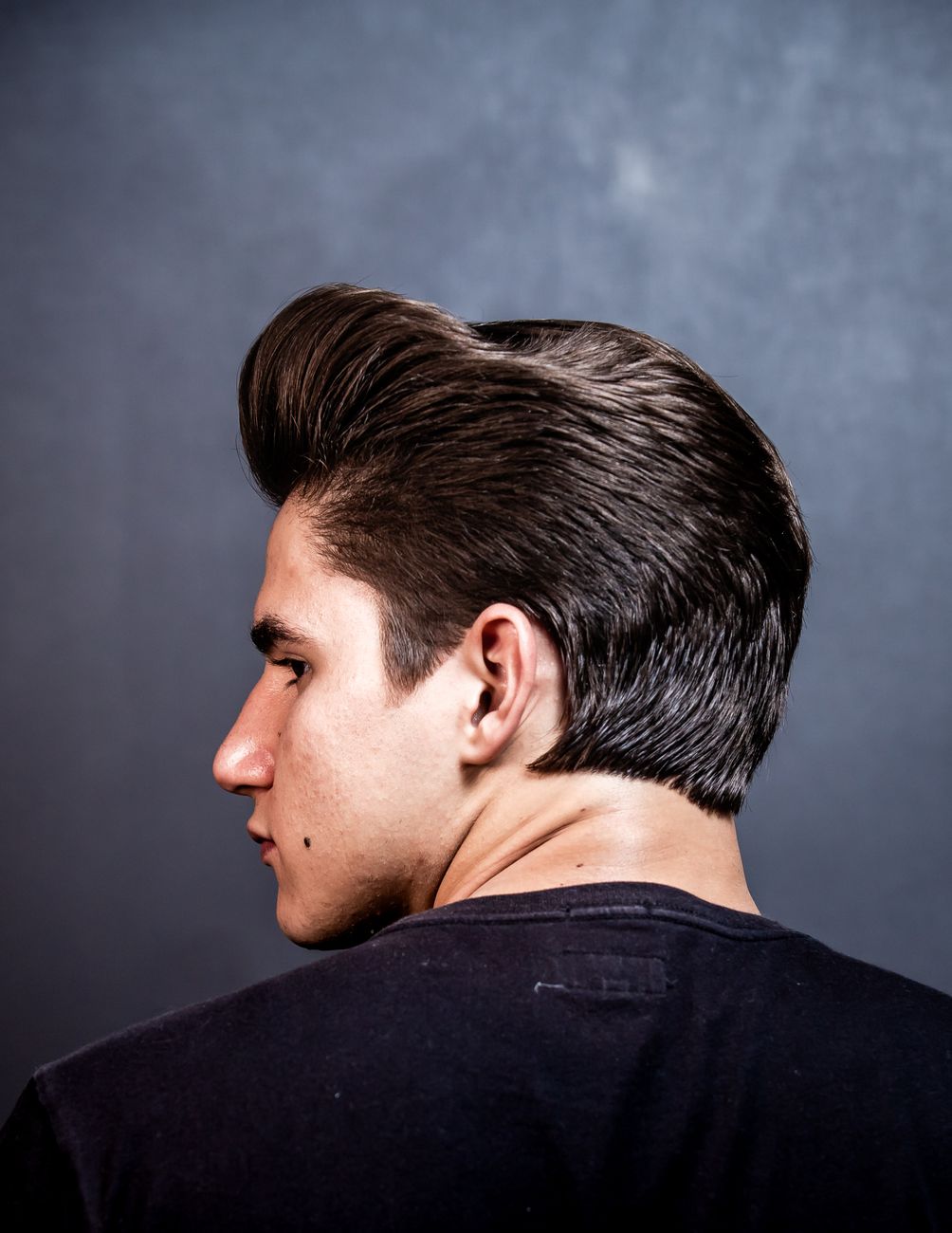 Homme de profil, cheveux longs sur le dessus coiffés en arrière avec du volume