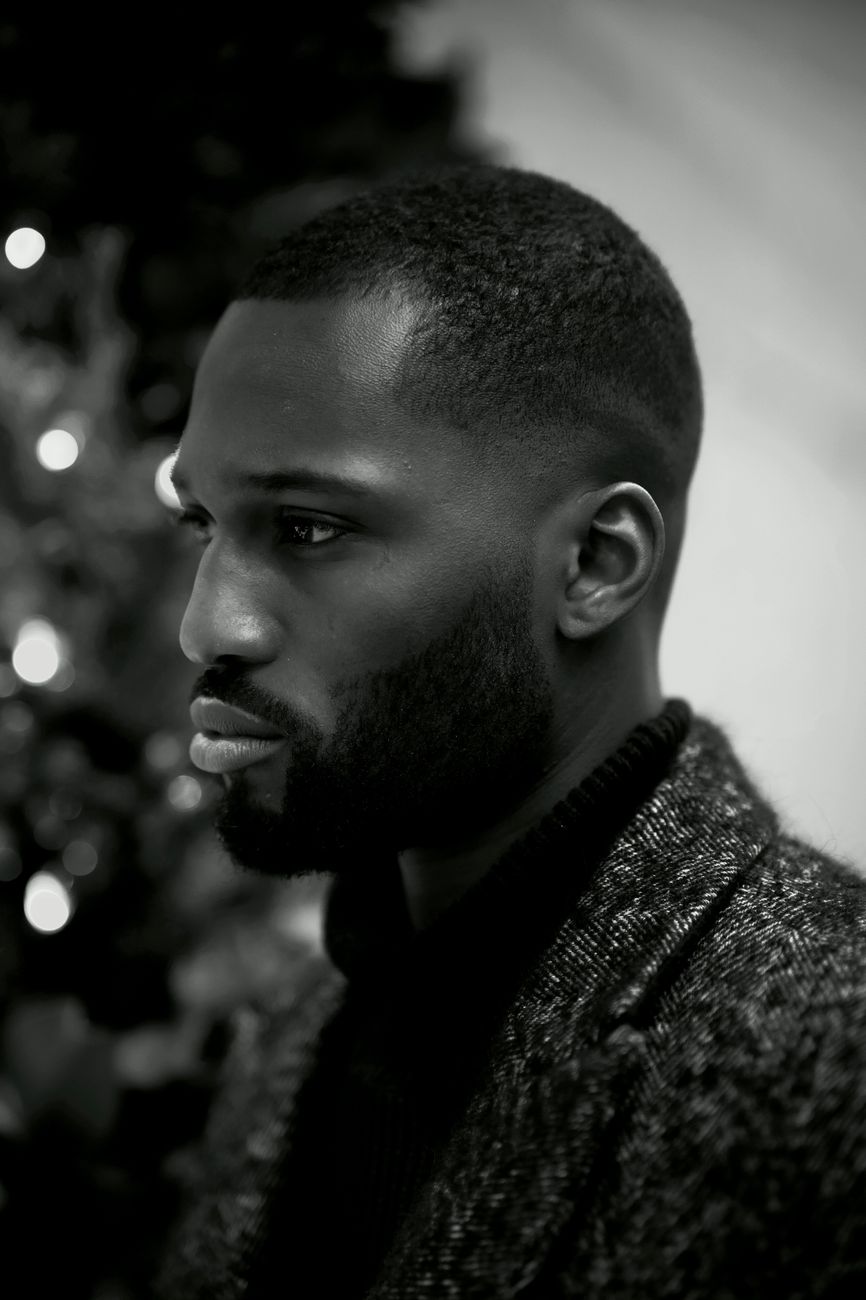 Homme de profil aux cheveux crépus très courts et à la barbe taillée