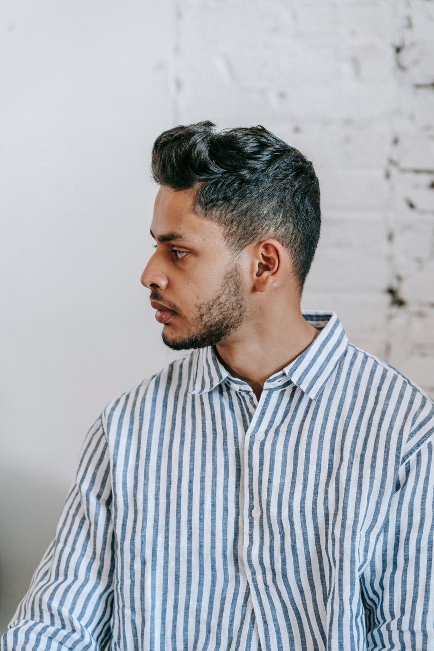 Homme de profil au dessus volumineux et côtés courts, chemise rayée