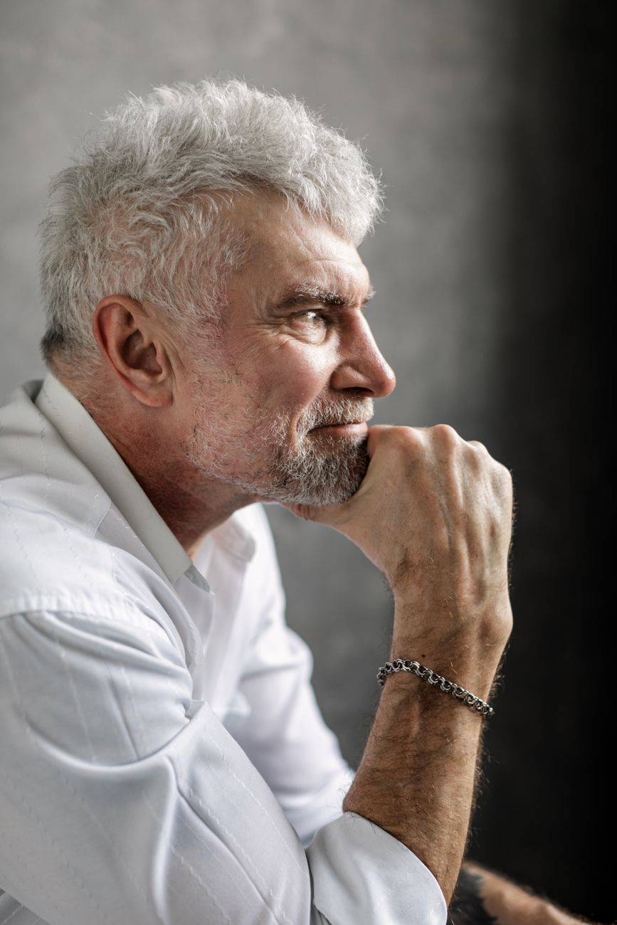 Homme aux cheveux gris argentés et à la barbe courte, de profil